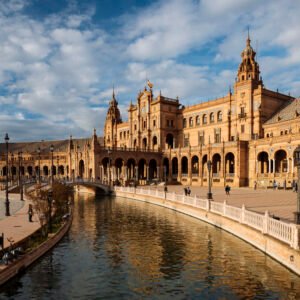 Golden Sunlight Bathes The Majestic Spanish Plaza, As Visitors Meander Along Its Ornate Bridges