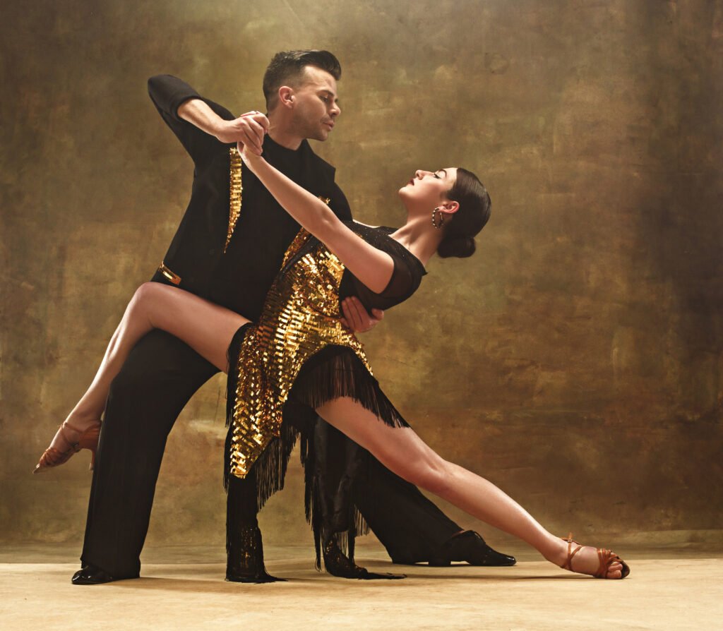 Dance Ballroom Couple In Gold Dress Dancing On Studio Background.